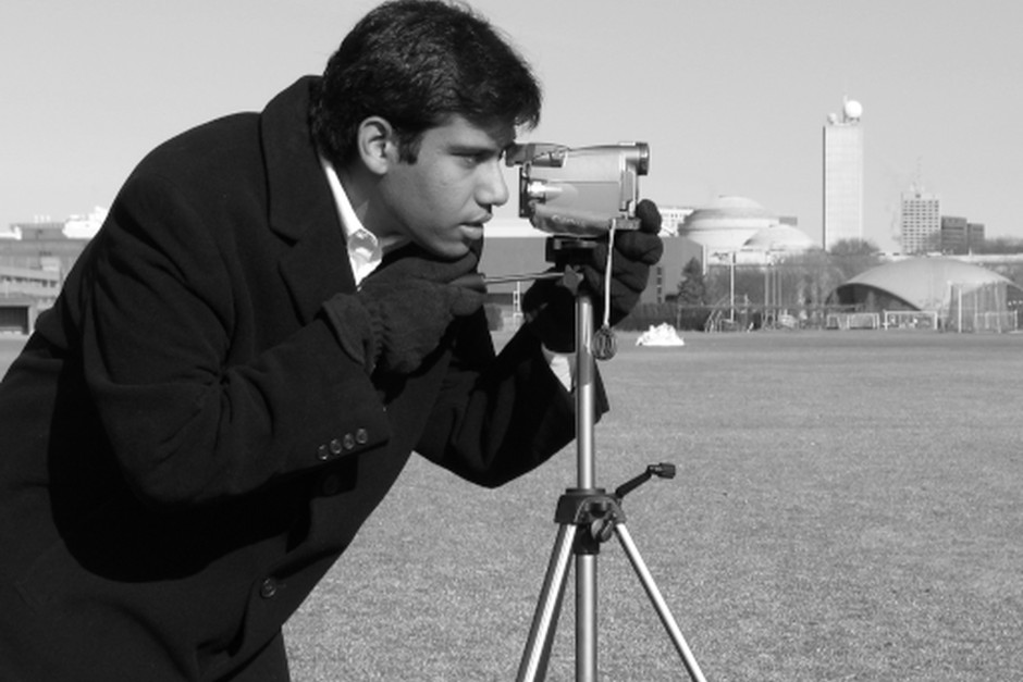 A photographer working carefully with a camera, reflecting our attention to observation and visual storytelling.
